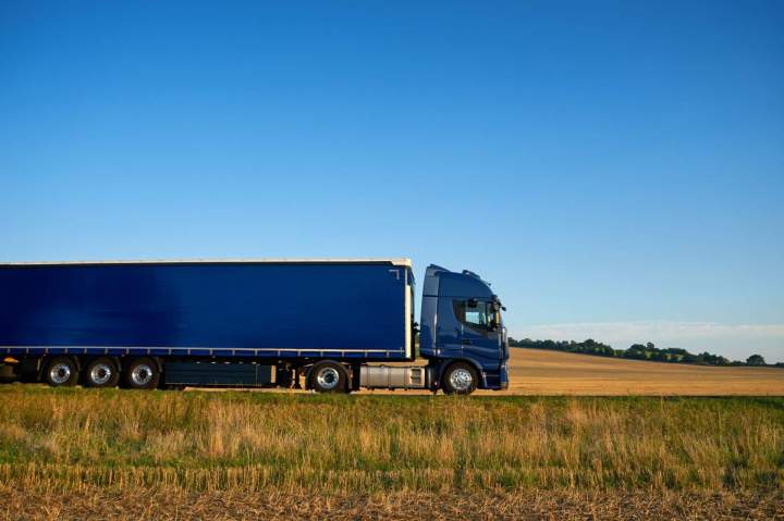 Vue dun camion de location moderne et propre, prêt pour un déménagement ou un transport de marchandises, avec un ciel bleu en arrière-plan.